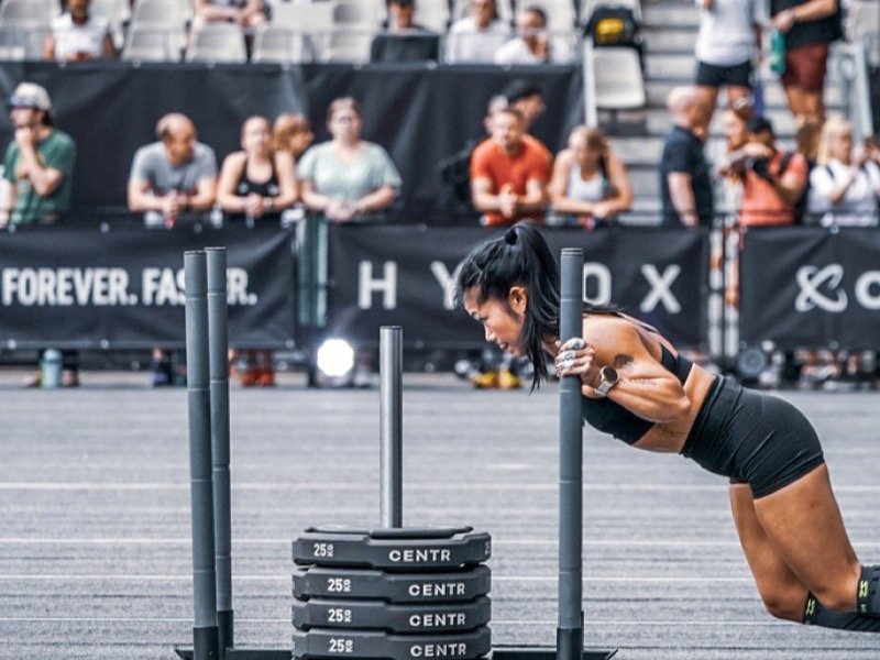 An athlete on the sled push at a HYROX race